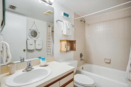 Un baño con lavabo, inodoro y bañera. en Caprice 501, en St Pete Beach