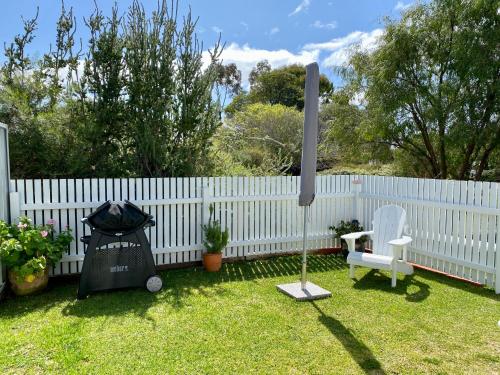 a yard with a white fence and a white chair at EcoLuxe in Dunsborough