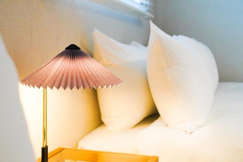 a room with a bed with pillows and a lamp at Branchera Naha 1405 in Naha