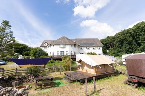 a large white house with a tent in front of it at Tabist Kiyosato Grandeur Yatsugatake in Hokuto