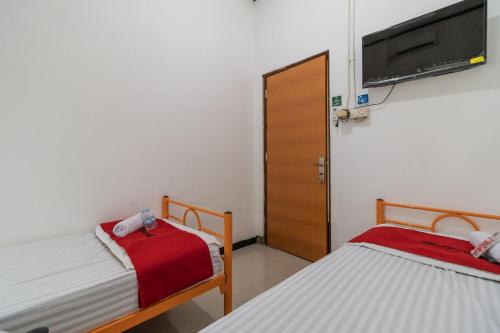 Postel nebo postele na pokoji v ubytování RedDoorz near Terminal Bubulak Bogor