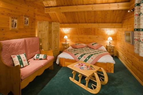 a bedroom with a bed and a couch in a cabin at Le Chalet d'en Hô in Névache