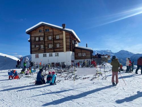 eine Gruppe von Personen vor einer Skihütte in der Unterkunft Chalet Sepp in Belalp