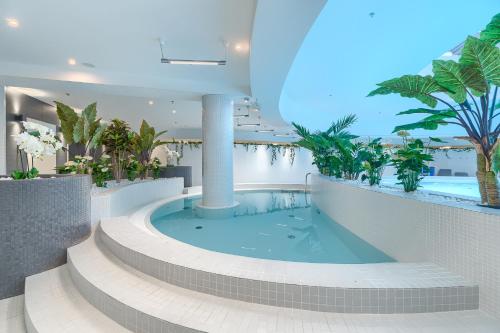 een hot tub in een gebouw met een zwembad bij Apartament Ariela LUX 17th fl HANZA in Szczecin