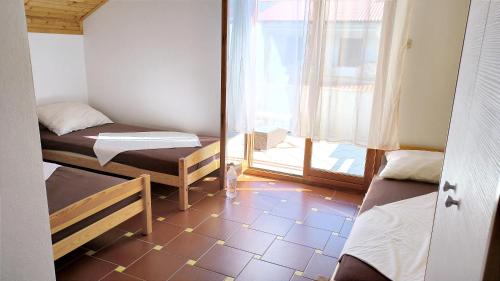 mały pokój z 2 łóżkami i oknem w obiekcie Gumla House w mieście Stara Novalja