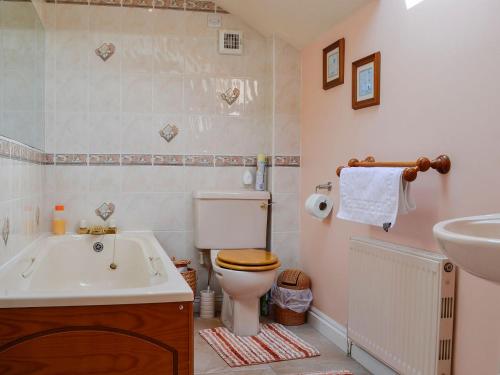 Cider Press Cottage في Blakeney: حمام مع حوض ومرحاض ومغسلة
