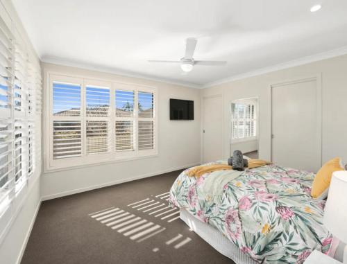 a bedroom with a bed and windows and a tv at Guest House On Guy in Forster