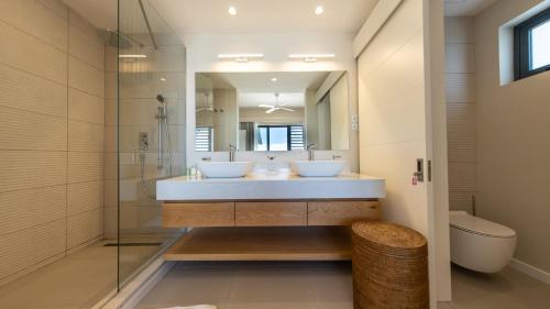 a bathroom with two sinks and a mirror at Blue Nest by Horizon Holidays in Pointe d'Esny