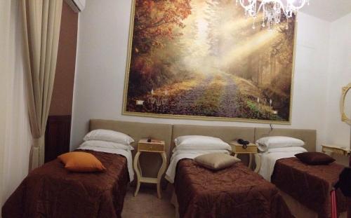 a room with four beds and a painting on the wall at Hotel des Artistes in Naples