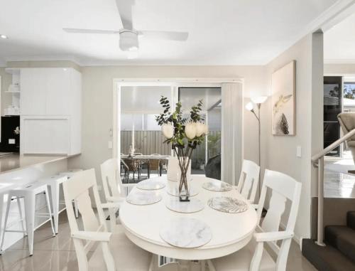 a white dining room with a white table and chairs at Guest House On Guy in Forster