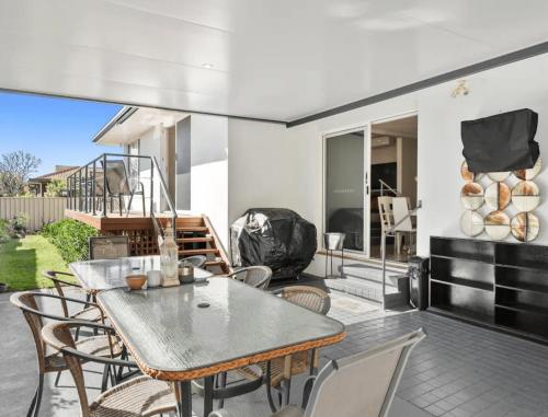 a dining room with a table and chairs on a patio at Guest House On Guy in Forster