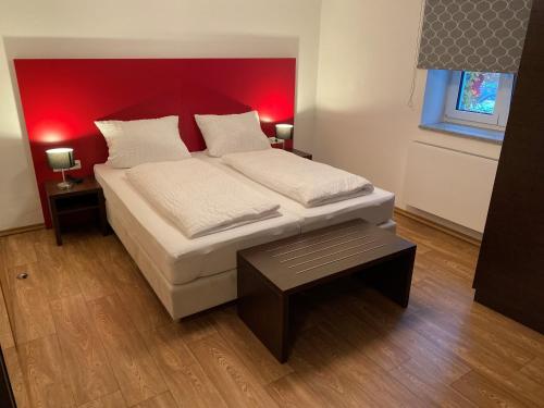 1 dormitorio con 1 cama grande y cabecero rojo en Gästehaus Linde Salching, en Salching
