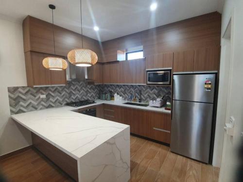 una cocina con nevera de acero inoxidable y armarios de madera en Executive Two Bedroom Villa For Hire in Nadi, en Nadi