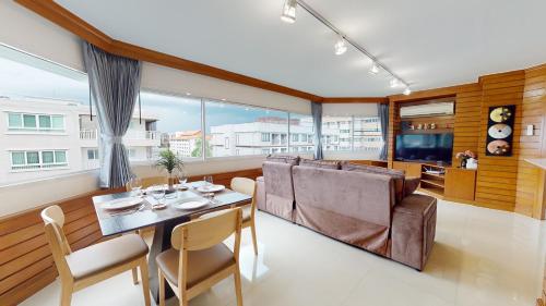 a living room with a table and a couch at Mountain & City View Panorama at Nimman in Chiang Mai