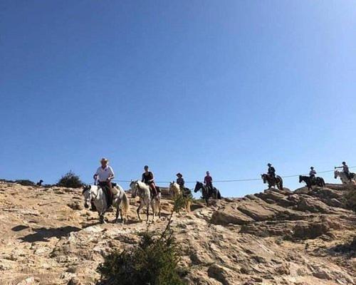 a group of people riding horses on a mountain at Happy Bedouin House Petra in Al Ḩayy