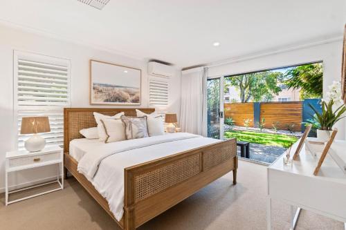 a bedroom with a large bed and a large window at By the beach 2 beach side 3 bedroom 2 bathroom home in Alexandra Headland