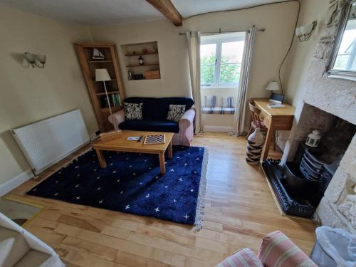 uma sala de estar com um sofá e uma mesa em Half-pint Cottage em Stroud