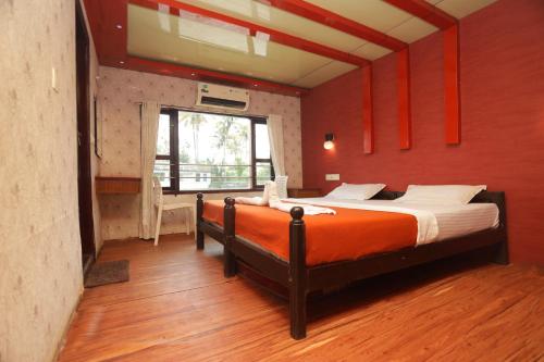 - une chambre avec un grand lit aux murs rouges dans l'établissement JCT Houseboat, à Alappuzha