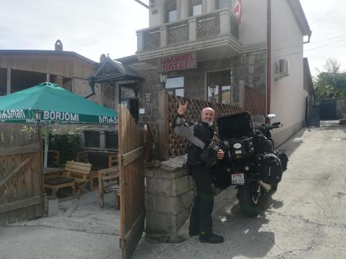 a man standing next to a motorcycle in front of a building at Golden Gate in Akhaltsikhe