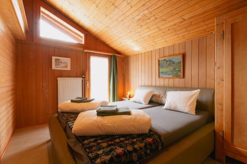 a bedroom with a bed in a wooden cabin at The Farmhouse in Sedrun