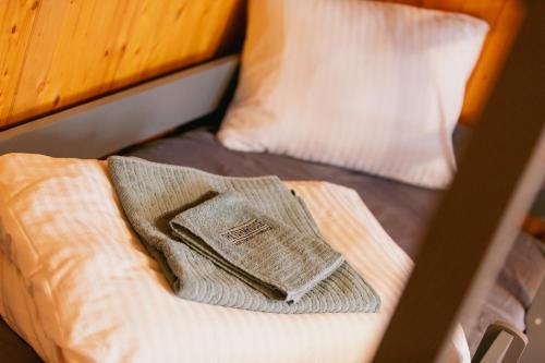 a towel sitting on a bed with two pillows at The Farmhouse in Sedrun