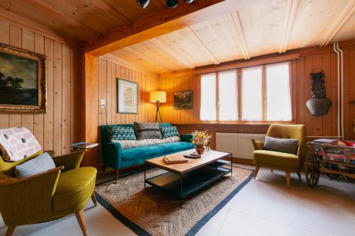 a living room with a couch and chairs and a table at The Farmhouse in Sedrun