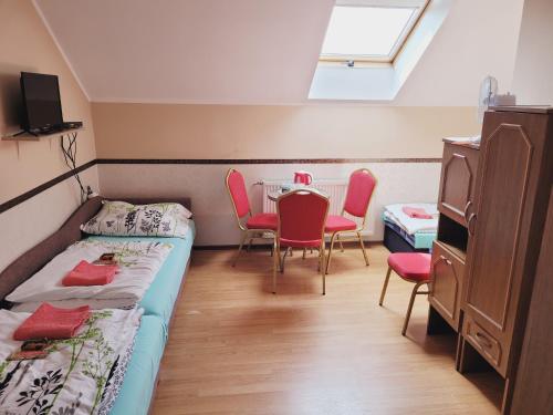 a room with two beds and a table and chairs at Delmajk in Mała Nieszawka