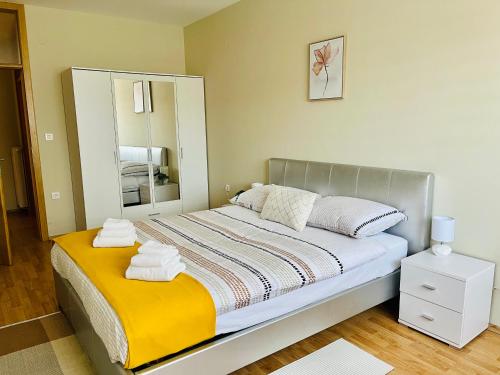a bedroom with a large bed with a yellow blanket at ALOM in Osijek
