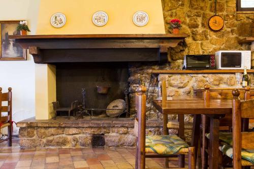 un camino in pietra in una stanza con tavolo e tavolo di All'Ombra di San Damiano ad Assisi