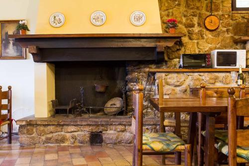 a stone fireplace in a room with a table and a tableablish at All'Ombra di San Damiano in Assisi