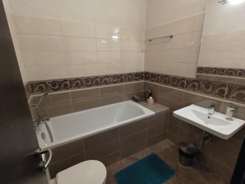 a bathroom with a tub and a toilet and a sink at Kaštieľ Ottlýk in Bánovce nad Bebravou