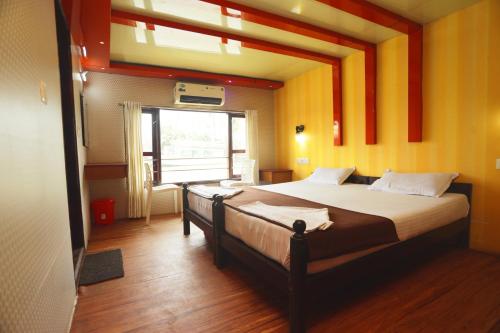 a bedroom with a large bed with orange walls at Harmony Houseboats in Alleppey