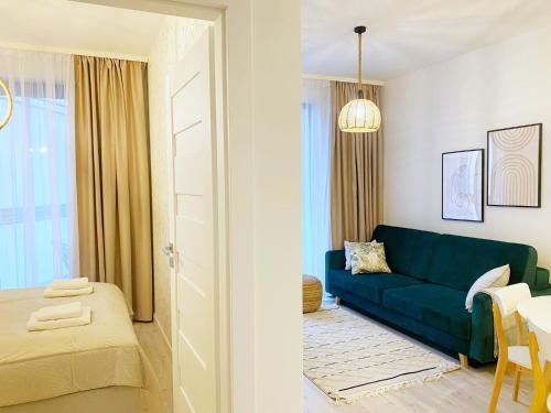 sala de estar con sofá azul y cama en Apartament BOHO SUMMER 71 Z Widokiem Na Morze - 365PAM, en Ustronie Morskie