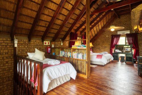 a bedroom with two beds and a book shelf at Shebamona No loadshedding in Marloth Park