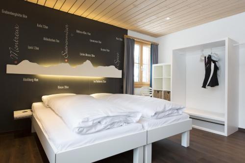 ein Schlafzimmer mit einem weißen Bett und einer schwarzen Wand in der Unterkunft Le Petit Relais in Gstaad