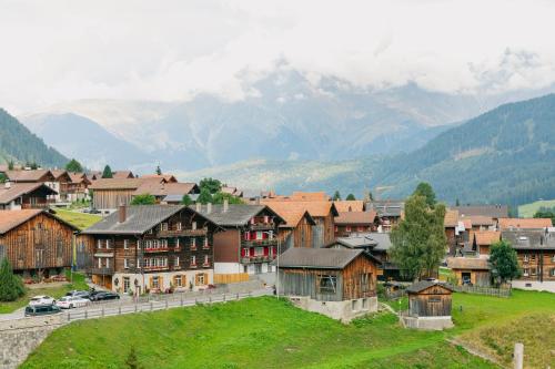 a town with houses and mountains in the background at The Farmhouse in Sedrun