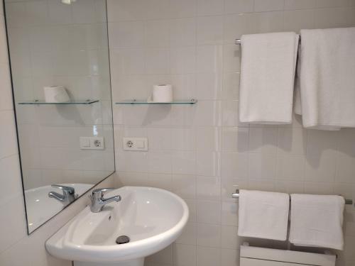 a bathroom with a sink and a mirror and towels at Hospedería San Froilan in Lugo