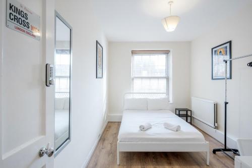 a white room with a bed and a mirror at APlaceToStay Central London Apartment, Zone 1 KIN in London