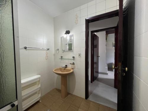 a bathroom with a sink and a toilet and a mirror at Casa Vivá Guaeca in São Sebastião