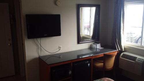 a room with a desk with a television on the wall at Royal Inn Motel in Watertown