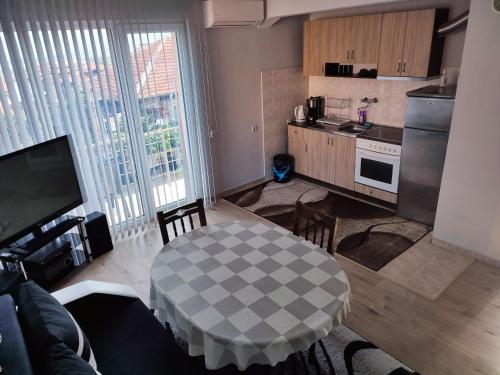 ein Wohnzimmer mit einem Tisch und einer Küche in der Unterkunft Apartment Daiv in Saparewa Banja