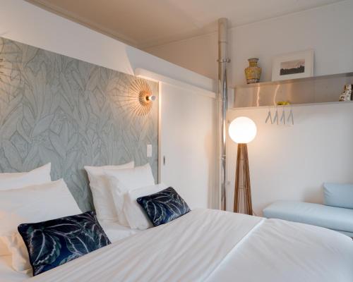 - une chambre avec un lit blanc et 2 oreillers bleus dans l'établissement La Maison de Chestret, à Liège