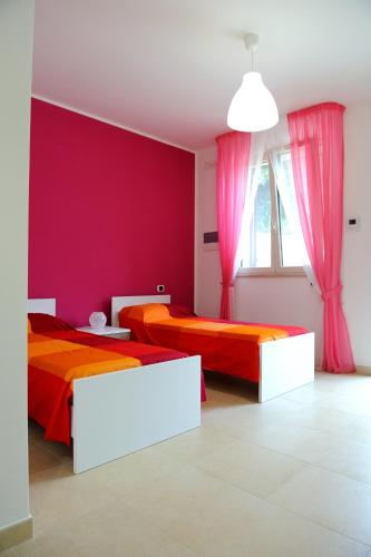 two beds in a room with red and orange at B&B Sun House in Modugno