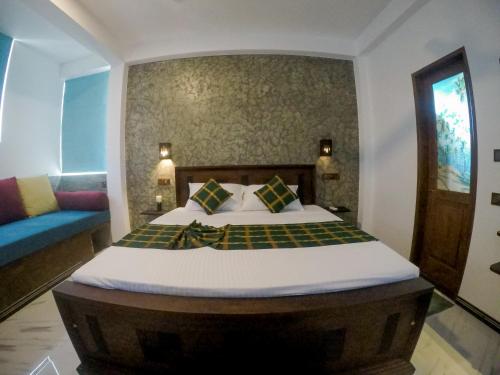 a bedroom with a bed and a blue couch at Villa Evergreen - Hikkaduwa in Hikkaduwa