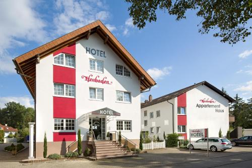 a hotel with a red and white building at Hotel Heuboden in Umkirch