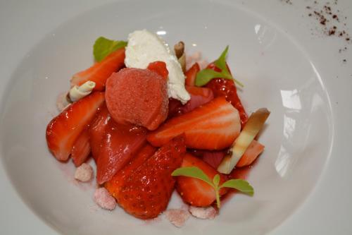 a white plate of food with strawberries and powdered sugar at Fitschen am Dorfteich in Wenningstedt