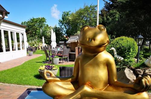 a statue of a mouse sitting in a pool at Fitschen am Dorfteich in Wenningstedt