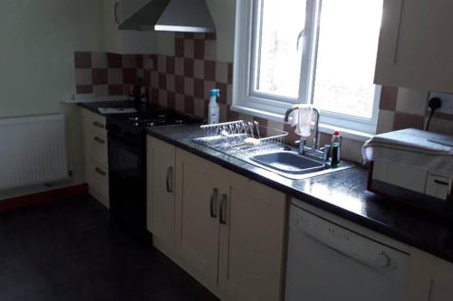cocina con fregadero y ventana en Porthcawl House Near Beach With Extensive Parking, en Porthcawl