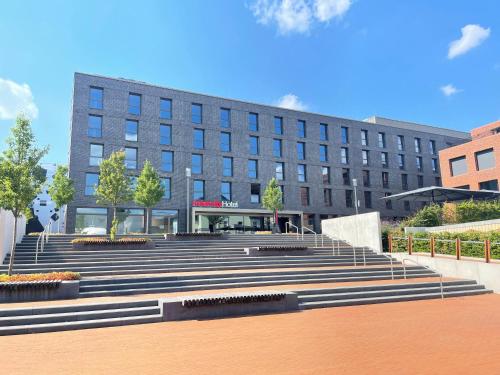 a building with a bunch of stairs in front of it at IntercityHotel Herford in Herford