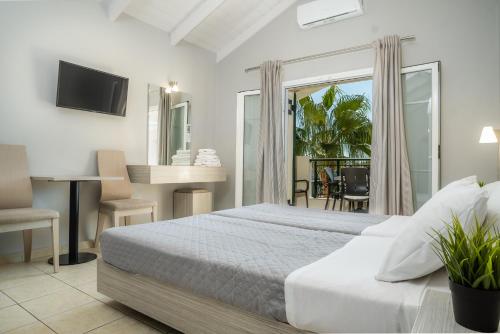 Schlafzimmer mit einem Bett, einem Schreibtisch und einem TV in der Unterkunft Zante Atlantis Hotel in Laganas